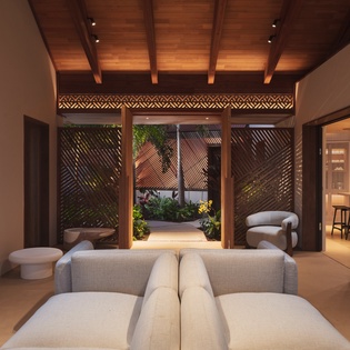 Unwind in your sophisticated living space where warm wood ceilings and contemporary furnishings create the perfect retreat for relaxation.