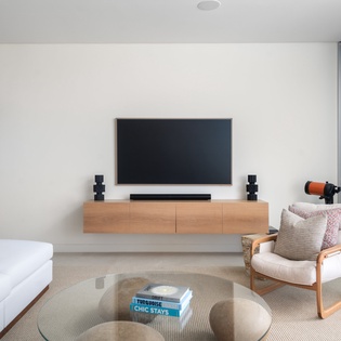 Unwind in your stylish living space featuring a large flat-screen TV, comfortable seating, and vibrant coral artwork creating the perfect atmosphere for relaxation.