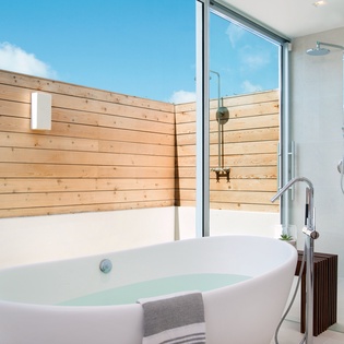 Soak in your private freestanding tub or refresh in the glass shower, both overlooking your secluded wooden-fenced courtyard.