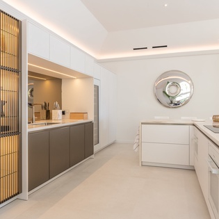 Your sleek modern kitchen awaits with elegant marble countertops and warm ambient lighting, perfect for creating memorable meals during your stay.