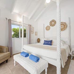 Unwind in your elegant four-poster bed beneath exposed beams, with coastal charm and modern comfort perfectly blended for your relaxation.