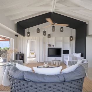 You'll love gathering in this stunning open-concept living space with soaring beamed ceilings and modern tropical style.