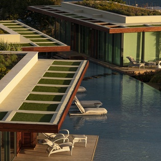 Modern architectural villa featuring contemporary design with swimming pool and tropical landscaping in a luxury resort setting.