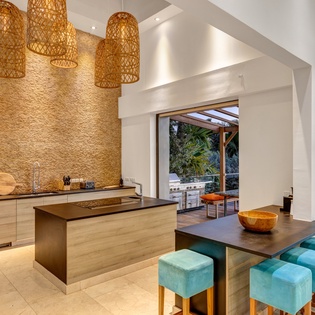 Your gourmet kitchen features natural textures and warm pendant lighting, creating an inviting space to prepare memorable meals during your stay.