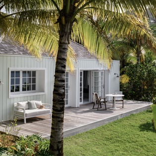 Charming cottage nestled among swaying palms, with your private deck where morning coffee tastes better in tropical paradise.