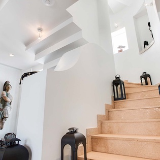 A striking white staircase adorned with elegant lanterns leads you to the upper levels, where modern architectural details create a bright, welcoming atmosphere.