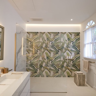 Step into your spa-like sanctuary with stunning tropical wallpaper, marble accents, and warm lighting that creates the perfect retreat.