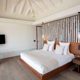 Unwind in your sophisticated bedroom featuring exposed beam ceilings, premium linens, and modern amenities for ultimate comfort.