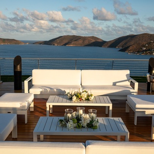 Elegant terrace seating with panoramic ocean and mountain views creates the perfect setting for your evening relaxation.