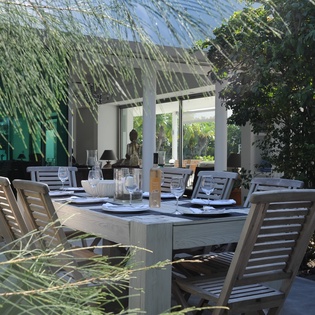 Dine al fresco at your private outdoor table, surrounded by lush tropical palms and modern elegance.
