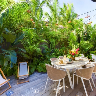 Enjoy tropical breakfast on your private deck surrounded by lush palms and vibrant blooms.