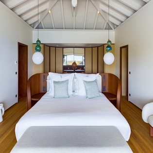 Your private sanctuary features soaring beamed ceilings and tranquil design, where crisp linens and warm wood create your perfect retreat.