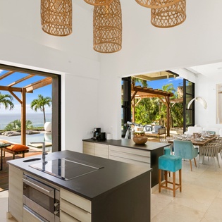 Your stunning open-plan kitchen flows seamlessly to tropical terraces, where ocean breezes and palm trees create your perfect island retreat.