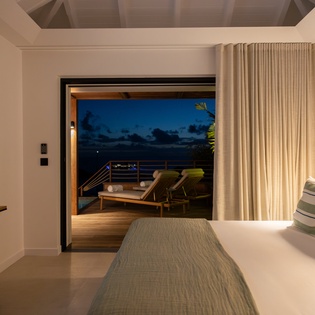 Drift off in your tranquil bedroom with direct access to a private terrace where ocean breezes and evening ambiance create perfect relaxation.