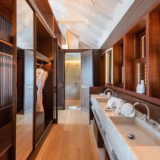Step into luxury with this stunning ensuite featuring dual sinks, rich wood cabinetry, and a spa-like shower beyond—your private retreat awaits.