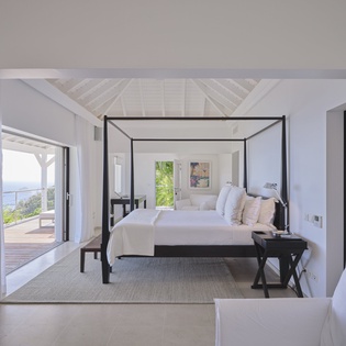 Rest in your luxurious four-poster bed while enjoying ocean views through floor-to-ceiling windows.