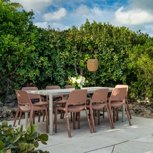 Gather around this inviting outdoor dining area, surrounded by lush tropical greenery and open skies. Perfect for memorable meals under the sun or stars.