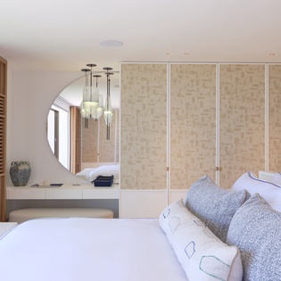 Rest in your serene bedroom featuring crisp linens, warm wood accents, and stylish pendant lighting for peaceful nights.