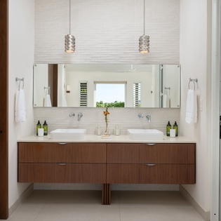 Luxurious dual vanity bathroom with modern floating walnut cabinetry, designer pendant lighting, and premium amenities to pamper yourself.