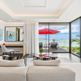 Relax in your bright living room with stunning sea views through floor-to-ceiling windows opening to your private terrace.