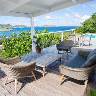 Relax in stylish wicker chairs on your private deck while soaking in breathtaking ocean views and tropical island scenery.