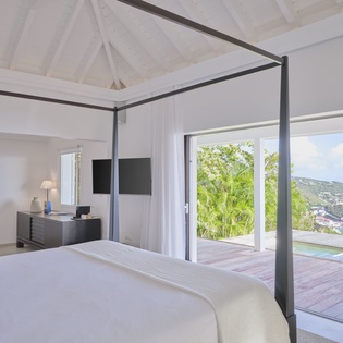 Wake up to stunning tropical views from your elegant four-poster bed, with direct access to your private deck.