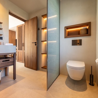 Your private bathroom features sleek modern design with warm wood accents, ambient lighting, and thoughtful touches for a spa-like experience.