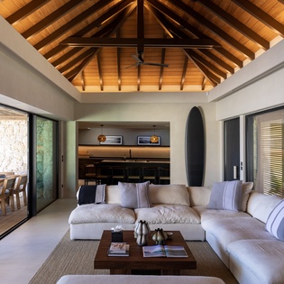 Relax under soaring wooden beams in this stunning open-plan living space, where modern comfort meets architectural elegance.