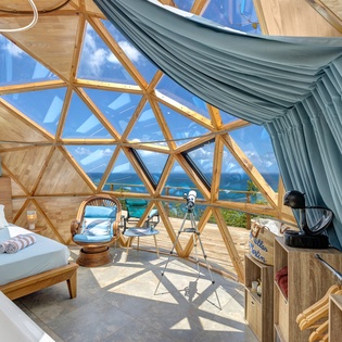 Wake up in your own geodesic dome with stunning ocean views framed by soaring windows and natural wood beams overhead.