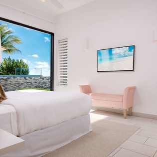 Wake up to bright island views through your bedroom window. Relax in crisp white linens with tropical breezes nearby and calming coastal artwork adorning your walls.