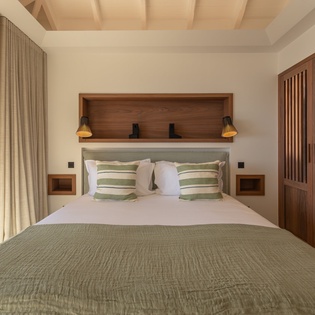 Sink into crisp linens and plush pillows in your serene bedroom sanctuary, where warm wood tones and soft lighting create the perfect retreat.