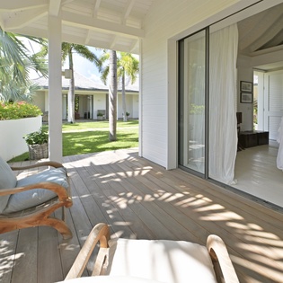 Relax on your private terrace where tropical breezes flow through, perfect for morning coffee overlooking lush gardens.