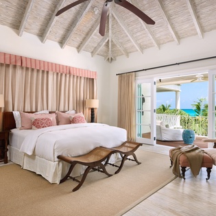 Your tropical sanctuary features a king bed, vaulted ceilings, and doors that open to a stunning turquoise sea view—perfect for relaxing mornings in paradise.