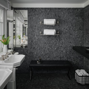 Unwind in your luxurious mosaic-tiled bathroom featuring dual sinks, a deep soaking tub, and plush towels for ultimate relaxation.