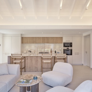 Your spacious open-plan living space features a stunning coffered ceiling and sleek kitchen with breakfast bar for casual dining.