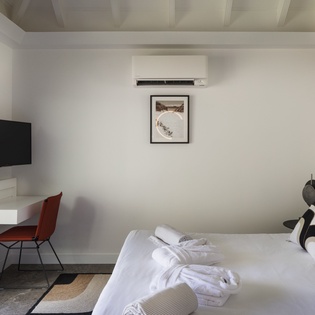 Your modern bedroom features crisp white linens, a wall-mounted TV, and climate control for perfect comfort after exploring.