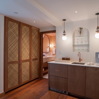 Your stylish kitchenette features warm wood cabinetry, elegant pendant lighting, and modern appliances for creating memorable meals together.