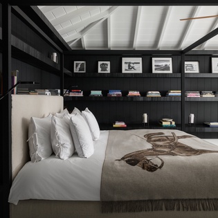 Drift off in your cozy retreat with crisp linens and curated books surrounding your canopy bed—literary dreams await.
