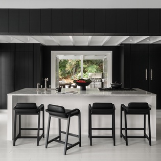 Sleek marble island with stylish bar seating creates your perfect space for morning coffee and evening cocktails.