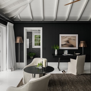 Your sophisticated retreat features dramatic beamed ceilings, elegant seating, and refined touches for ultimate relaxation.