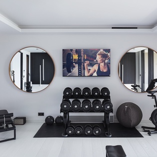 Your private fitness sanctuary features professional-grade equipment and stylish mirrors, perfect for maintaining your workout routine in luxurious comfort.