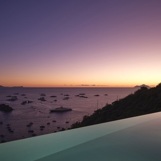 Infinity pool overlooking stunning harbor views during magical sunset hours, creating the perfect romantic evening ambiance.