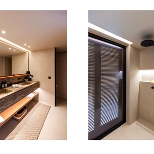 Your spa-like bathroom features warm wood vanities and a sleek walk-in shower with rainfall head.