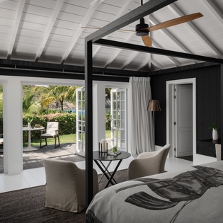 Unwind in your elegant bedroom suite with exposed beam ceilings, comfortable seating, and French doors opening to your private garden terrace.