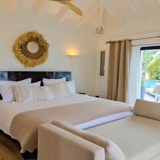 Wake up to crisp white linens, soothing neutral tones, and your own tropical pool oasis just beyond the glass doors—your peaceful island retreat awaits.