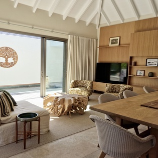 Relax in your open-plan living space where warm wood tones and comfortable seating create the perfect atmosphere for memorable moments together.