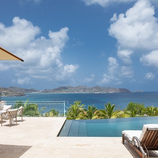Infinity pool terrace with pristine ocean views stretching to distant islands, where your days are spent lounging poolside under Caribbean sunshine.