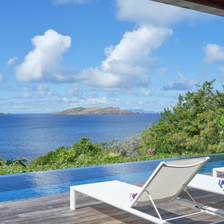Stunning infinity pool with panoramic ocean views and distant islands creates the perfect tropical escape backdrop.