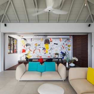 Sink into the plush sofas in your open-plan living space, where a soaring cathedral ceiling and vibrant artwork set a playful, contemporary mood for relaxing and reconnecting.