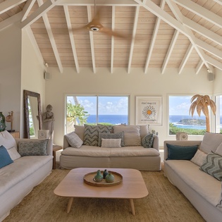 Settle into your bright, airy living room with soaring vaulted ceilings and stunning ocean views stretching across the horizon through expansive windows.